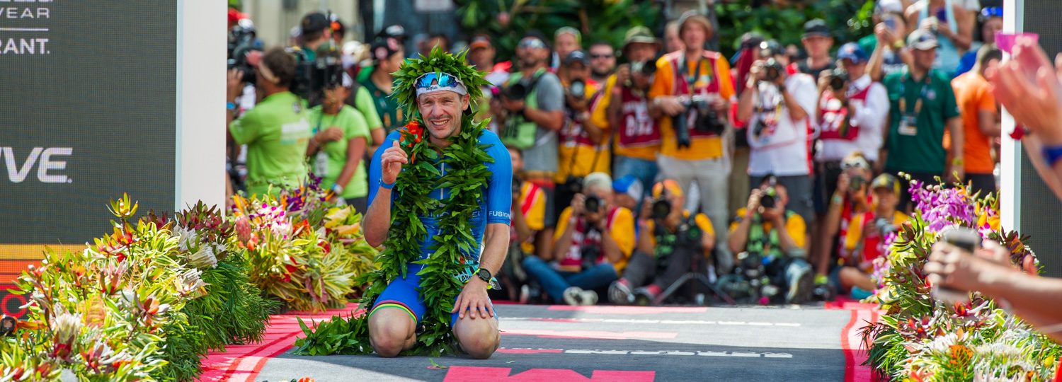 2018 Ironman World Champion Patrick Lange gives a shaka at the finish line.